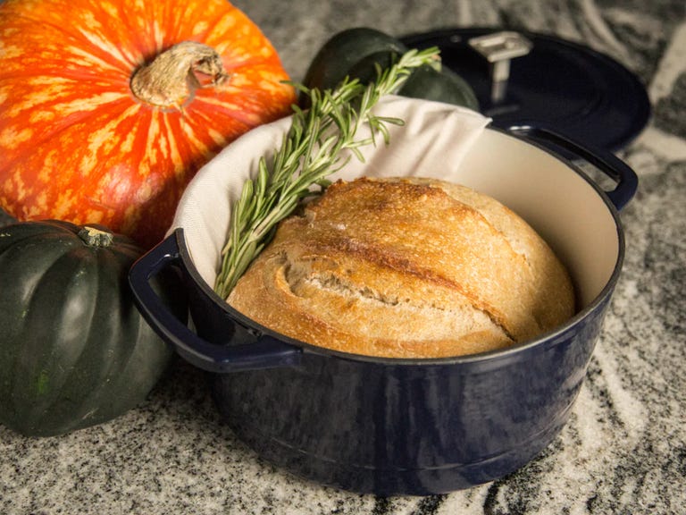 navy dutch oven with sourdough bread on table