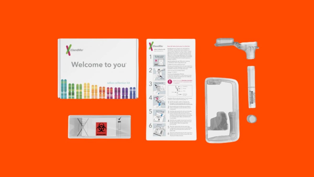 The contents of a 23andMe test kit arranged against an orange background.