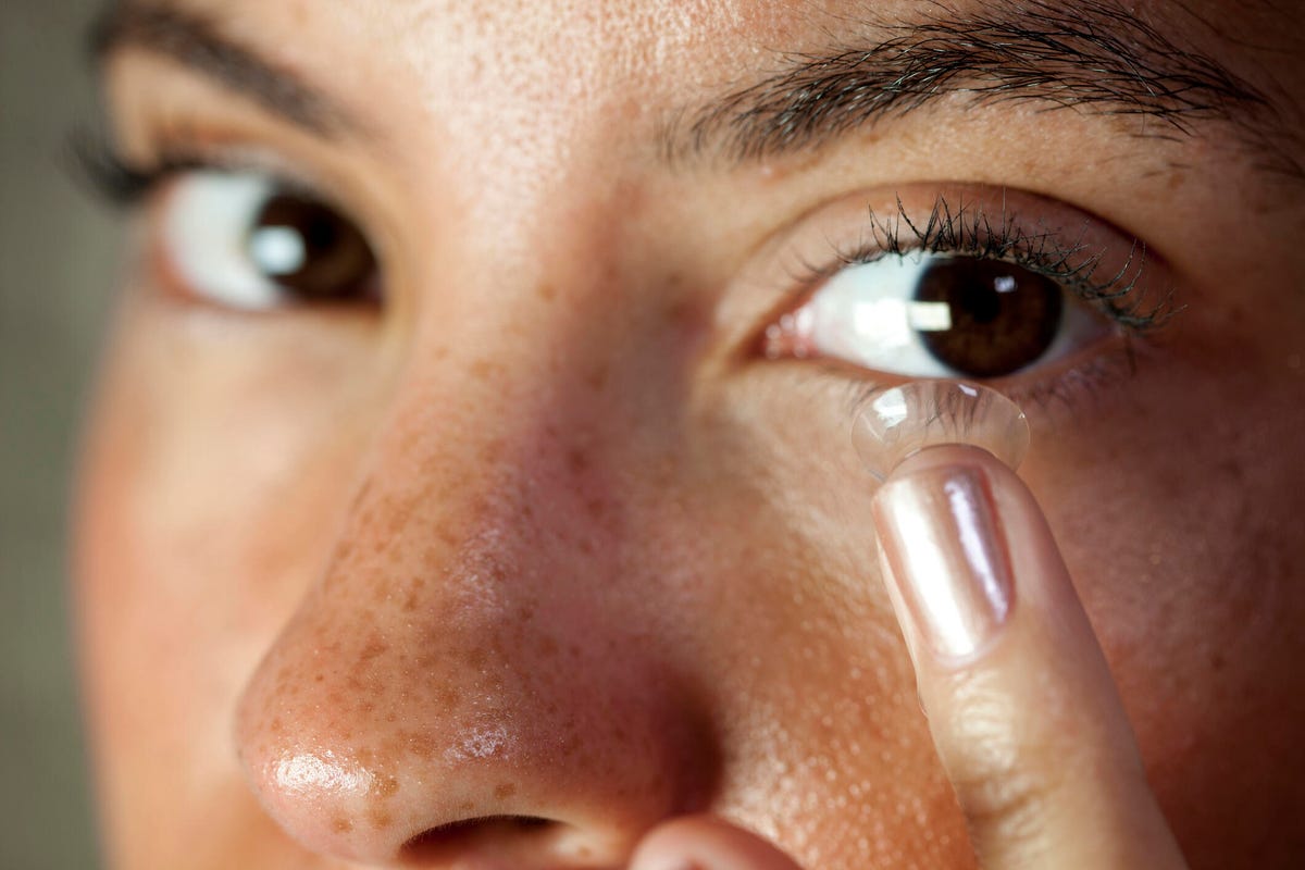 Close-up of person inserting a contact lens