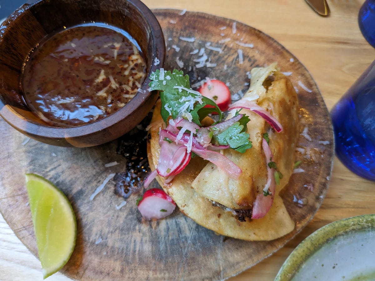 Two tacos on a wooden plate