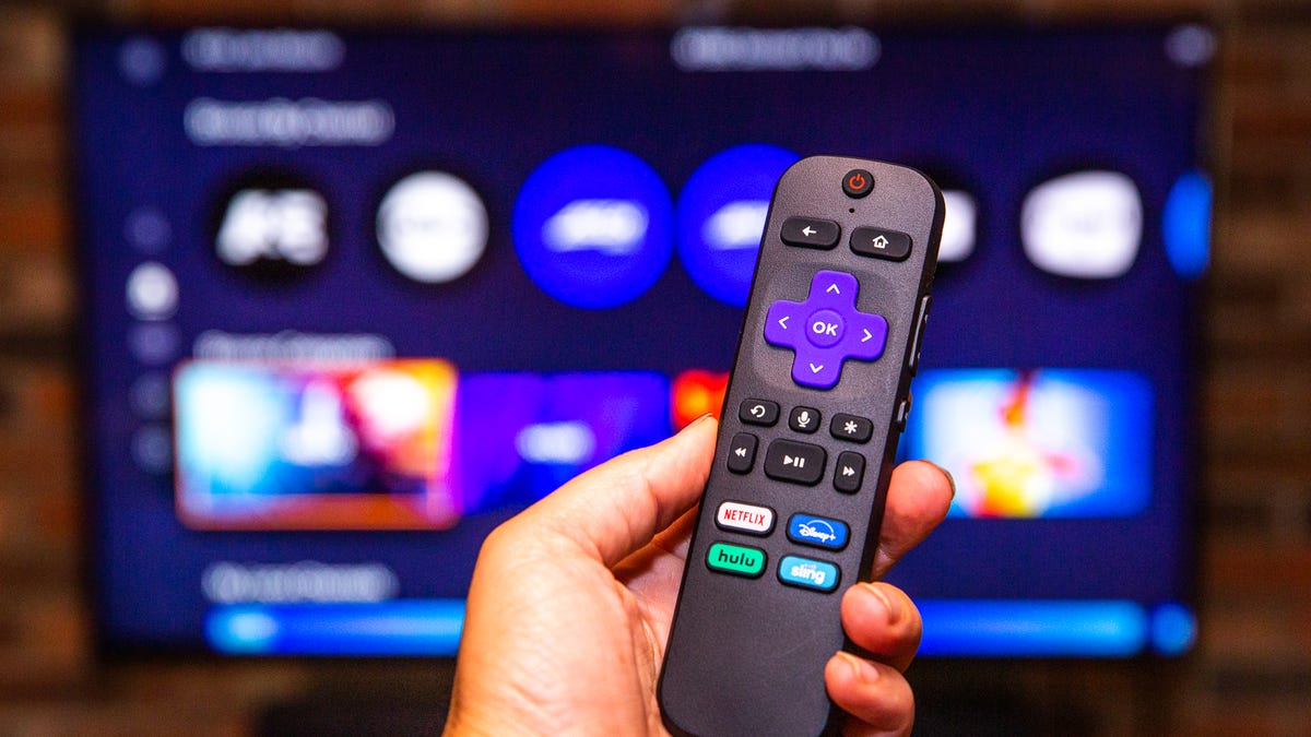 hand holding a remote in front of Sling TV on a Roku Ultra 4K 2021