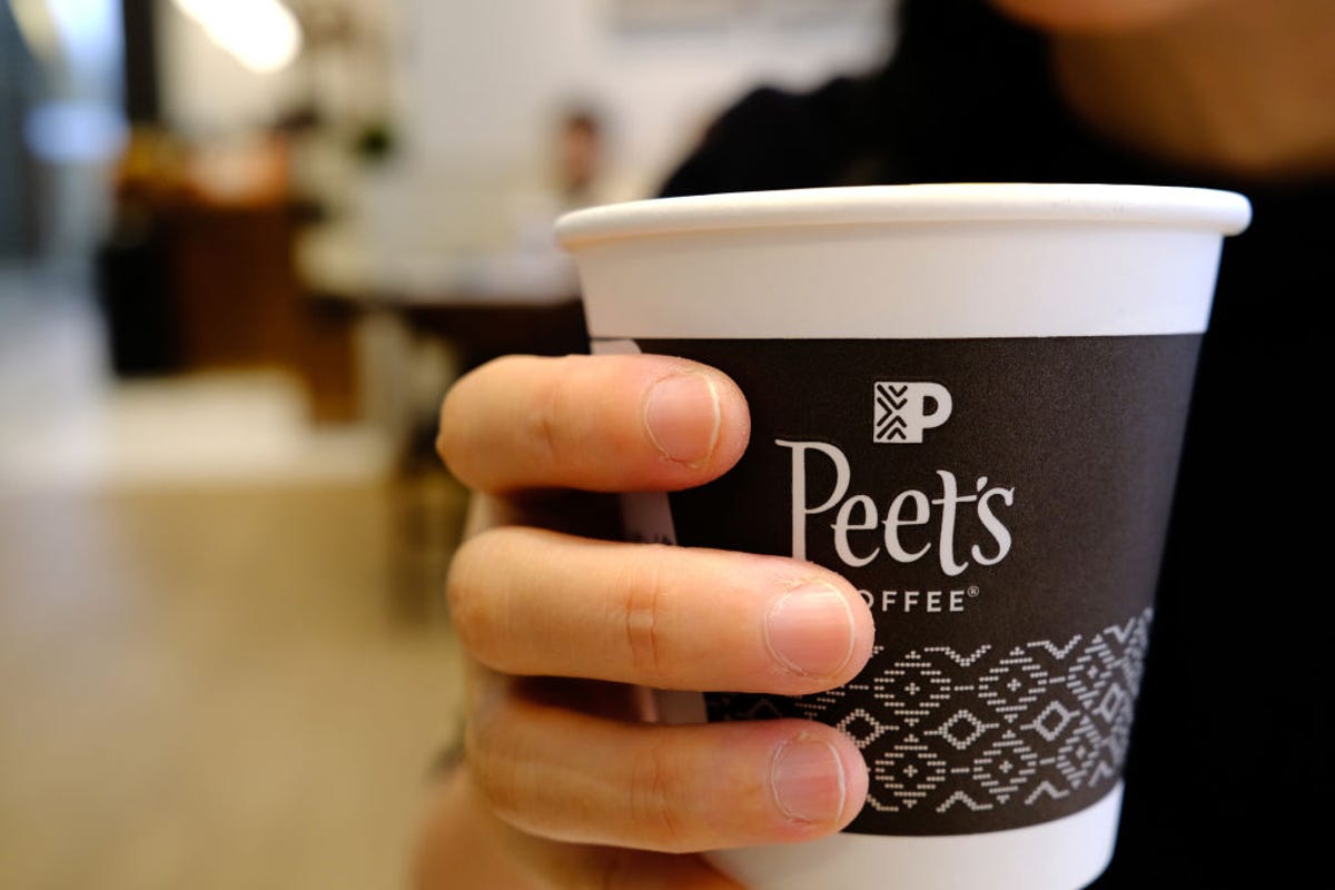 Woman holding Peet's coffee cup