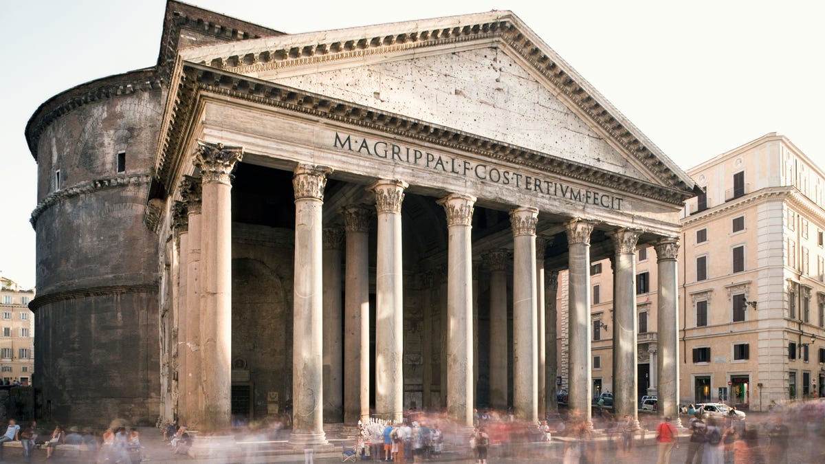 A long exposure image of Rome's pantheon surrounded by tourists walking around the structure.