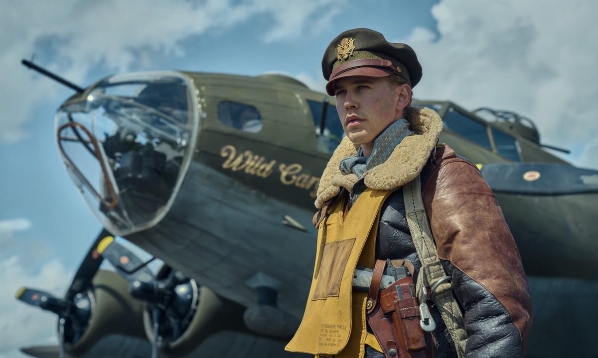 austin butler dressed as world war 2 era pilot standing in front of plane