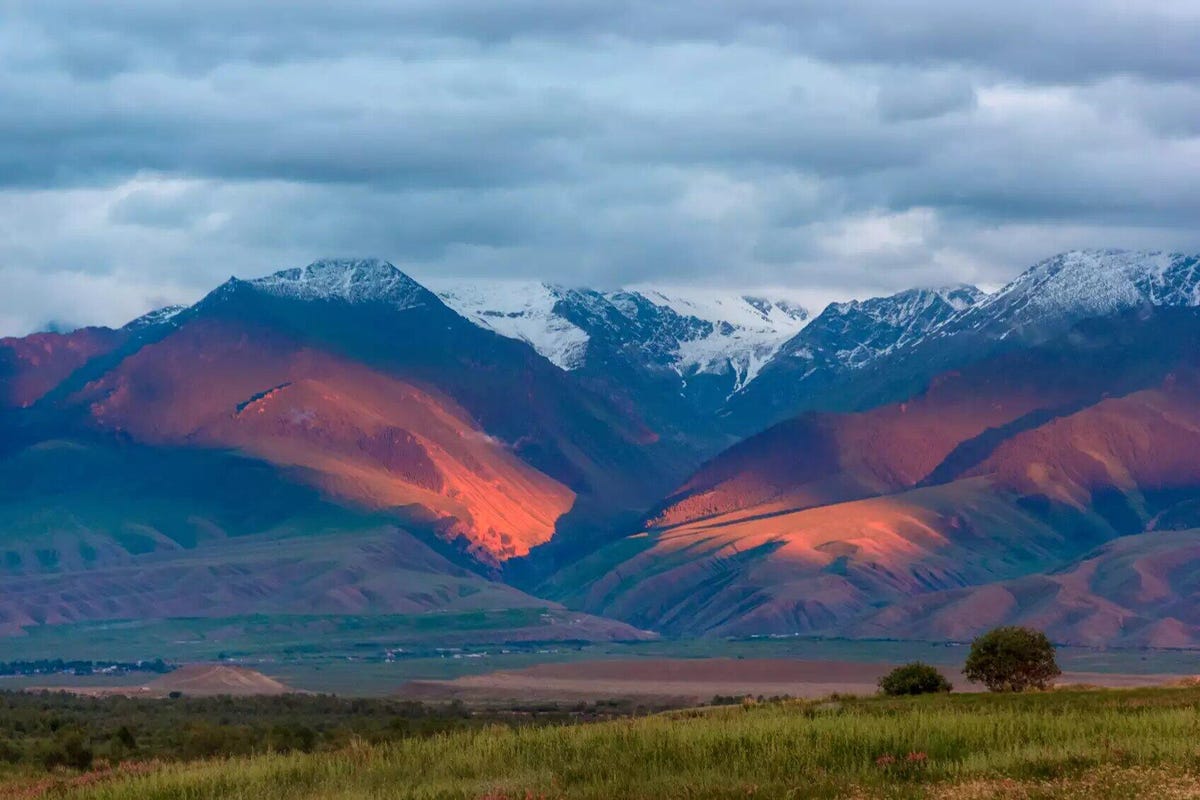 A view of the Tian Shan mountains showcasing colors like orange, indigo and faded violet.