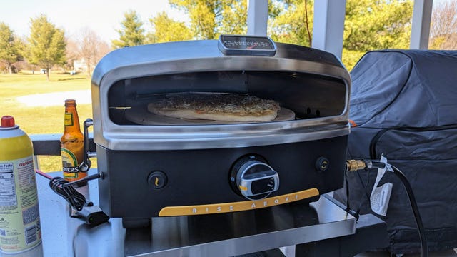 A pizza oven with a crisp apple cider next to it
