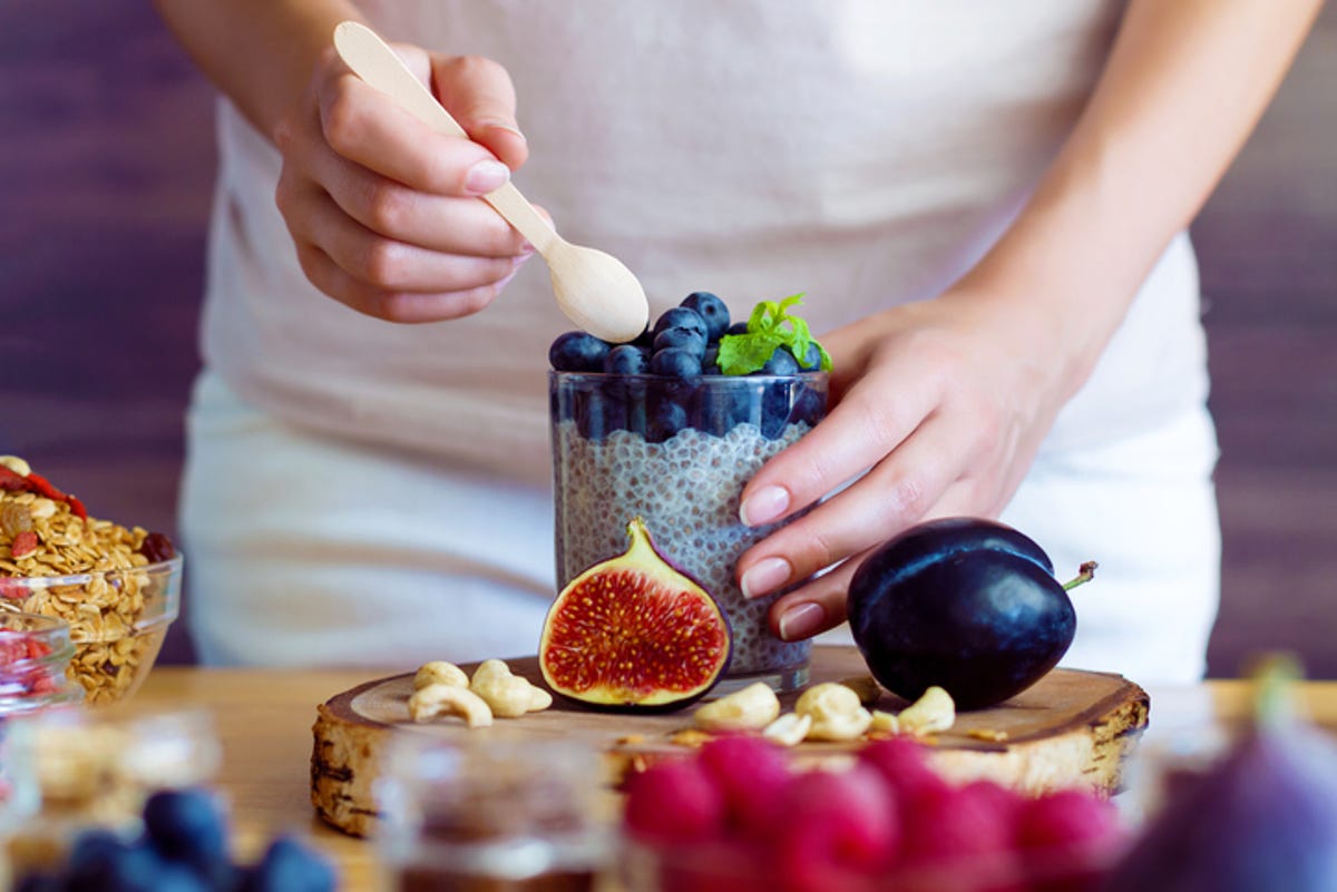 A person pouring a spoonful into a Chia and Blueberry Smoothie.