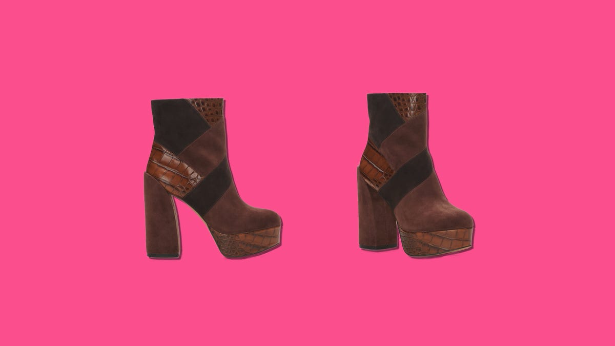 A pair of suede platform booties on a pink background