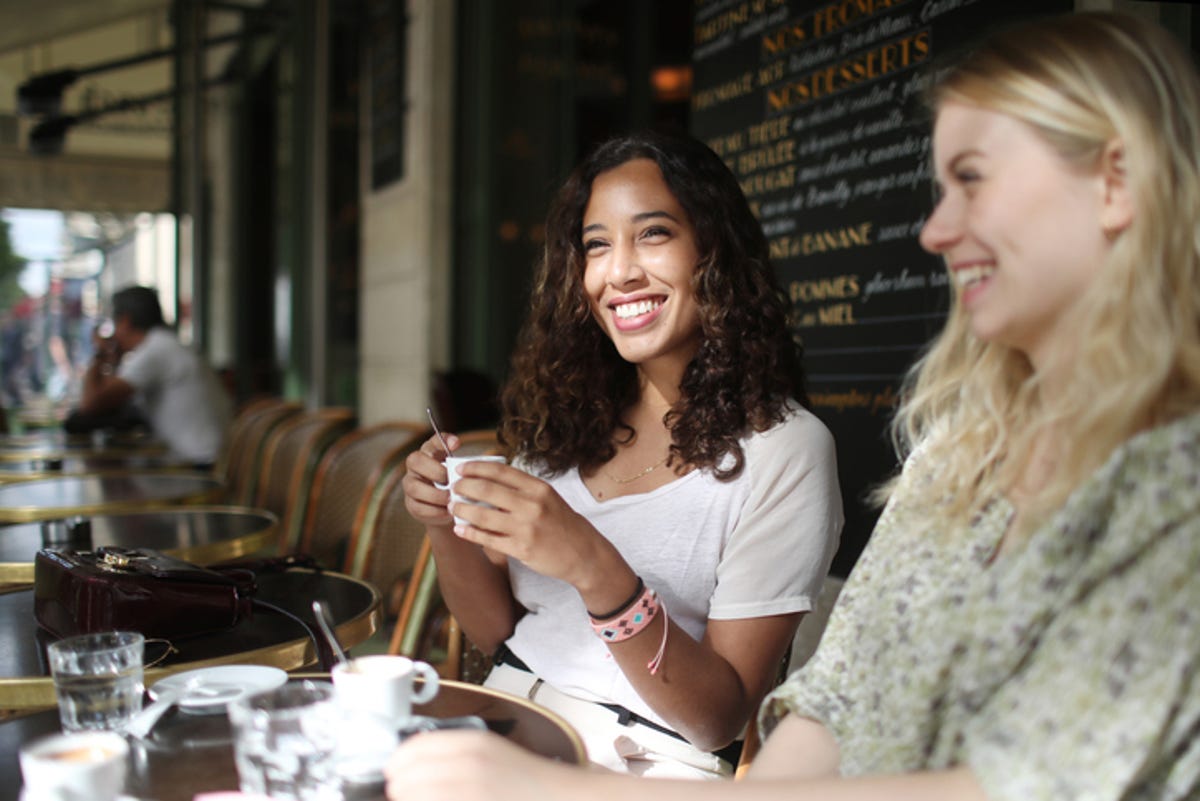 Deux jeunes femmes étaient assises sur la terrasse, buvant du café et riant.
