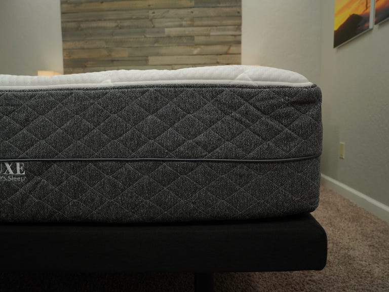 A closeup of the GhostBed Luxe mattress on top of a grey bed frame. 