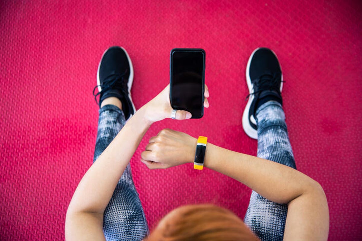 Close-Up Of Woman Using Mobile Phone At Gym