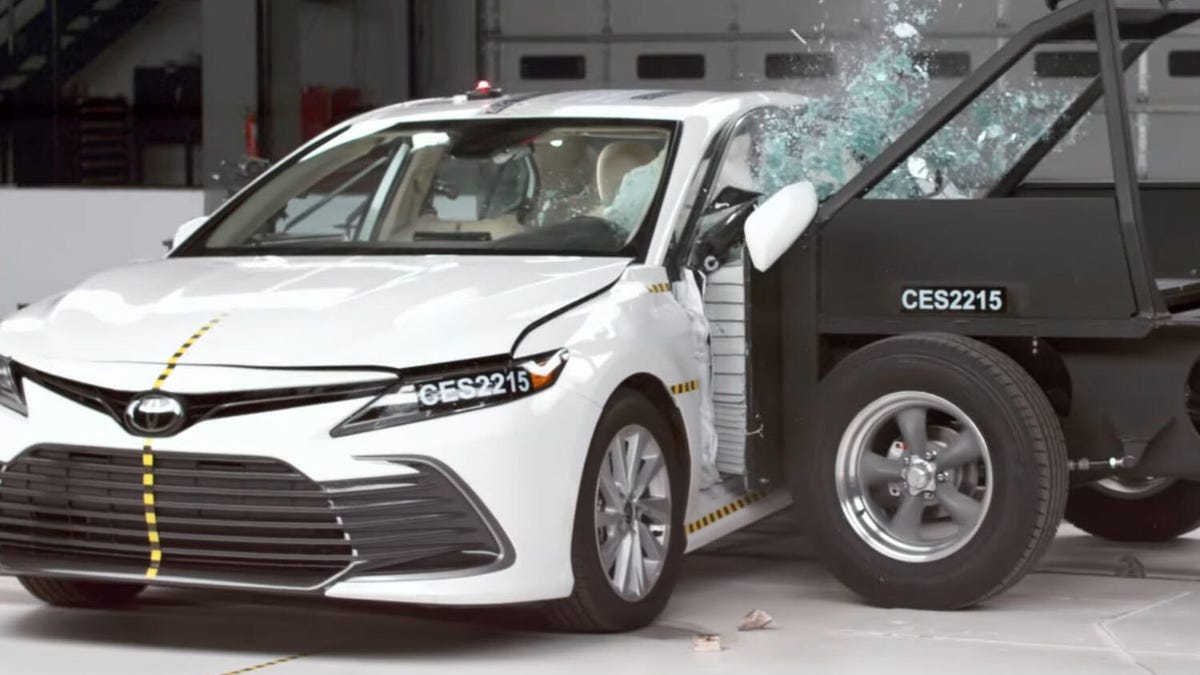 A white Toyota Camry gets rammed from the side in an IIHS crash test