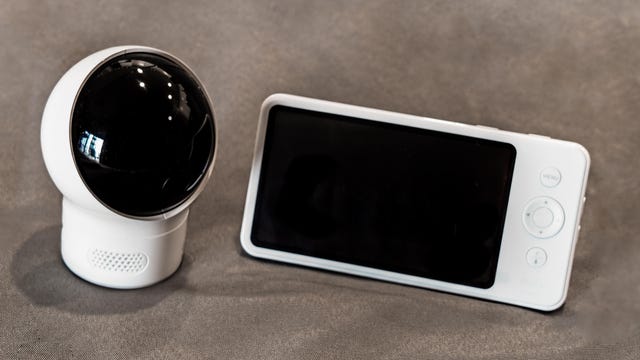 A white and black baby monitor against a sandy background 