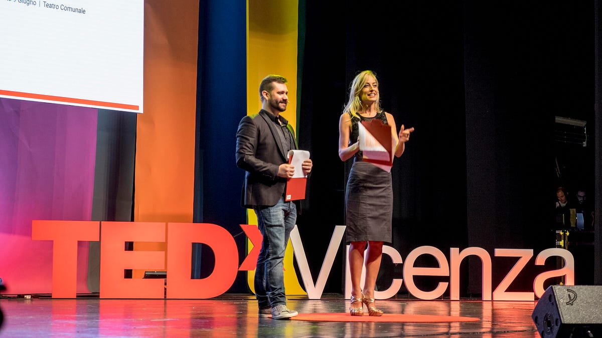 Presenters onstage during a TED talk