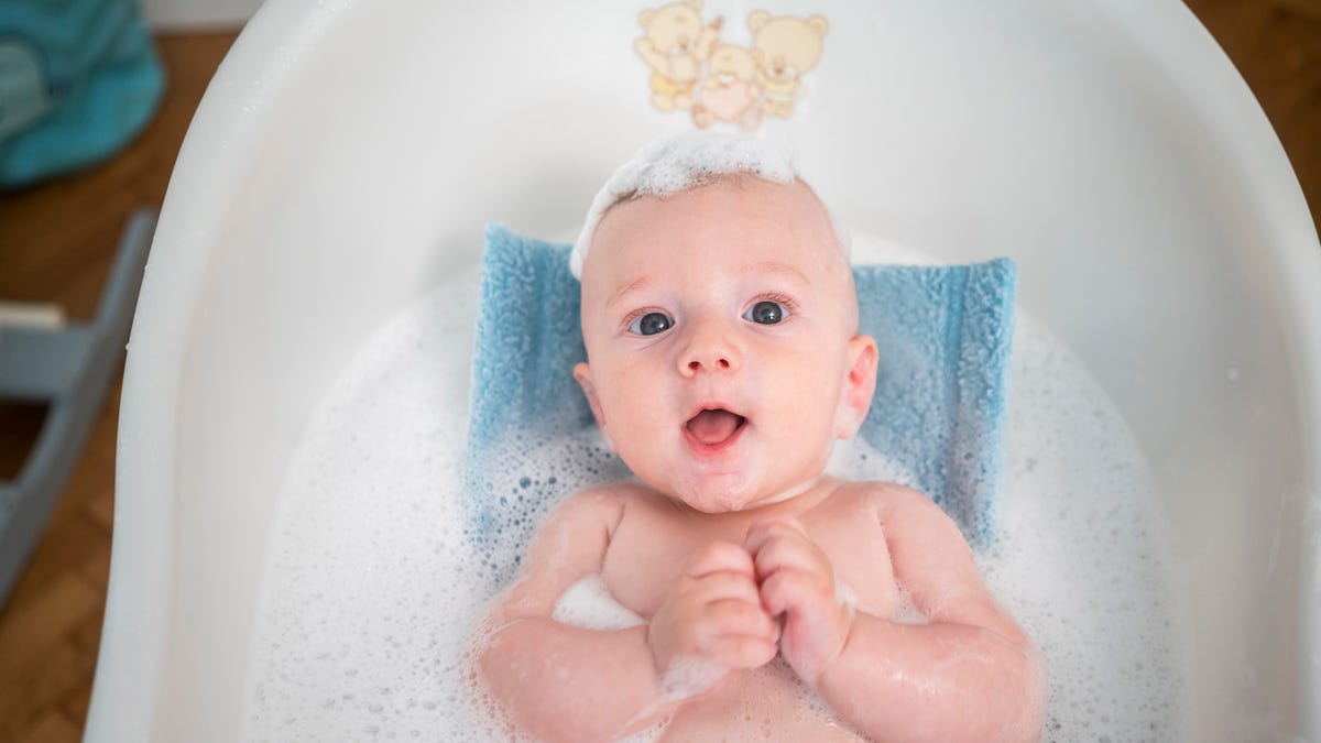 Baby taking bubble bath in a portable tub