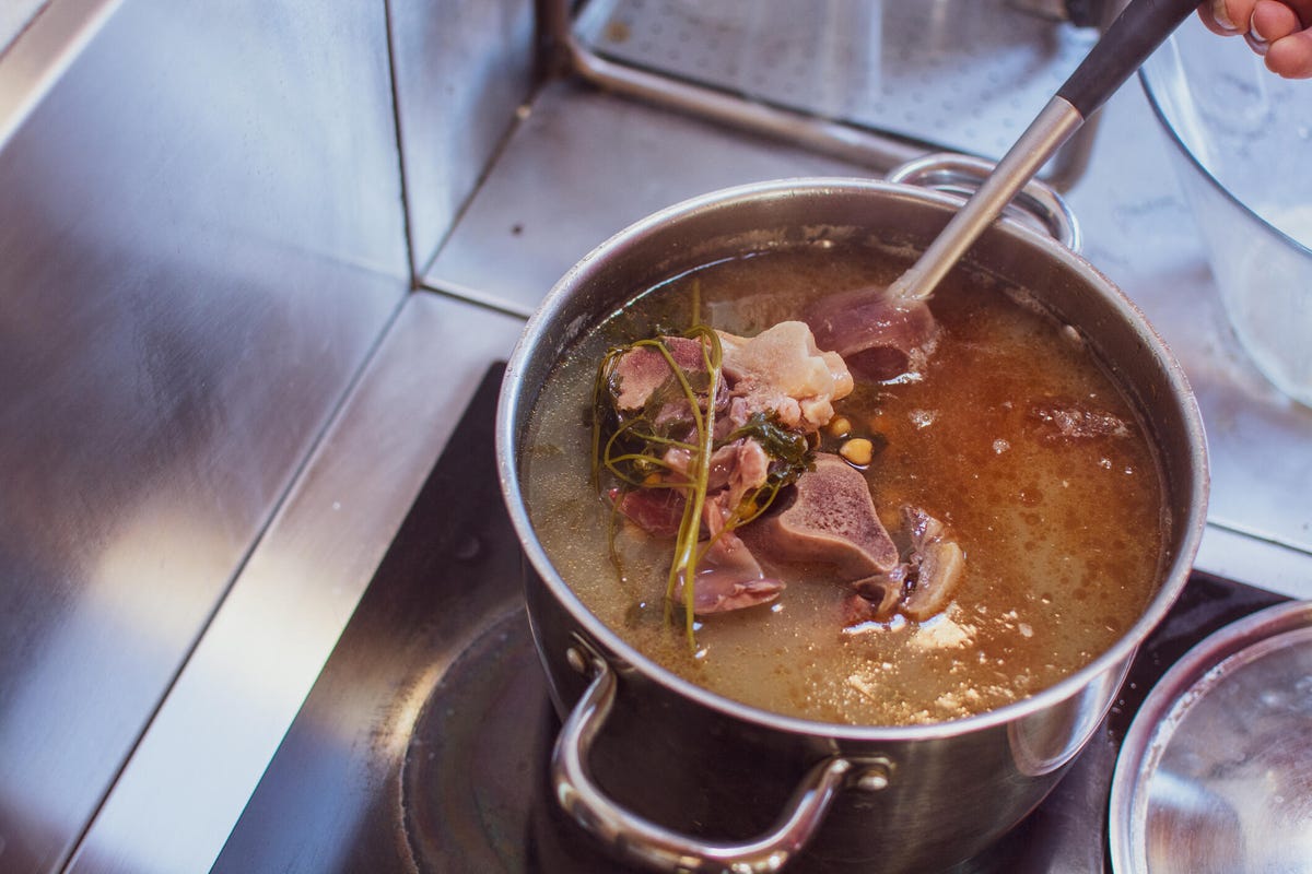 Cooking leftover bone broth in a large pot