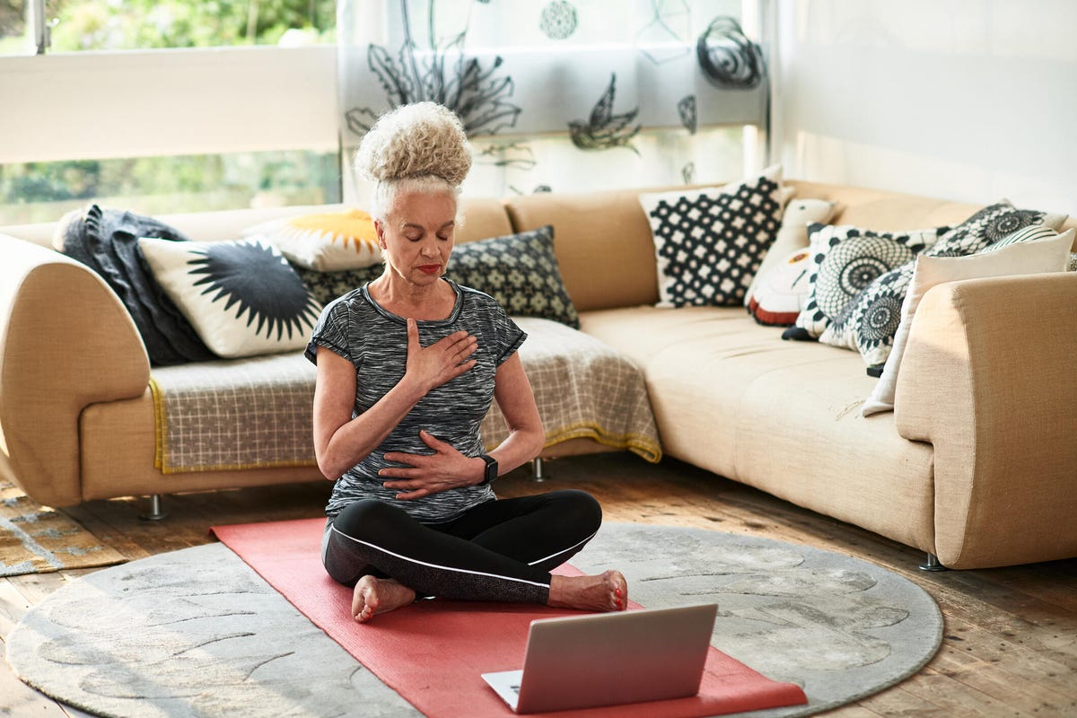 Woman concentrating on breathing exercises at home