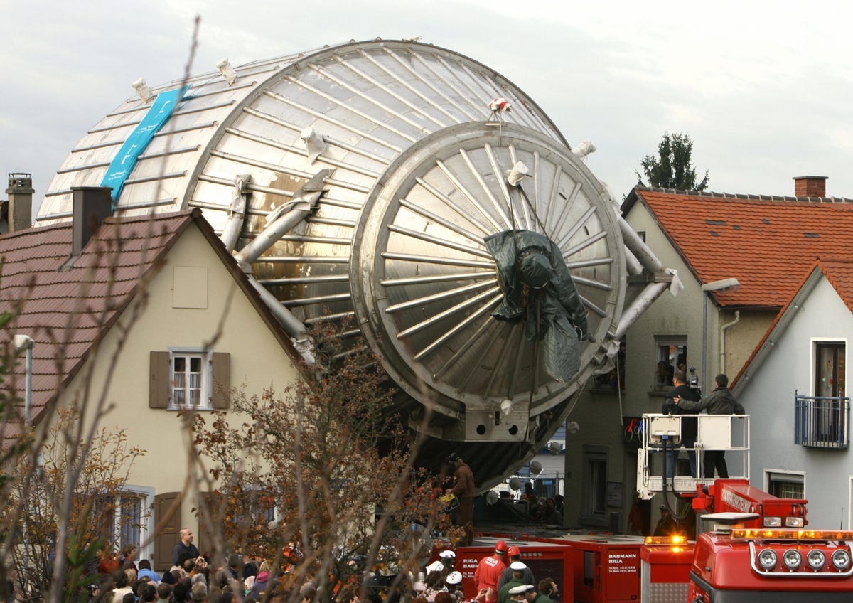 The barrel-shaped detector of the KATRIN is wheeled between houses near Leopoldshafen, southern Germany