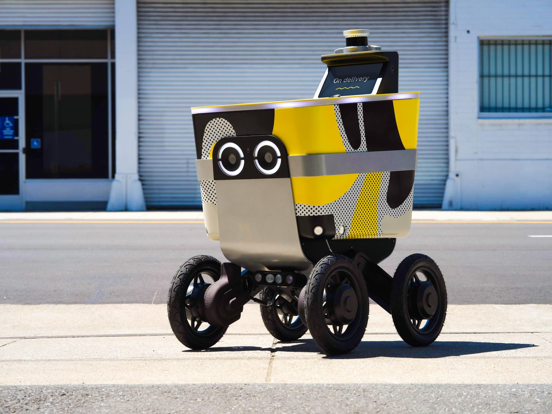 serve street bot, four-wheeled robot with yellow and black paint, big googly eyes