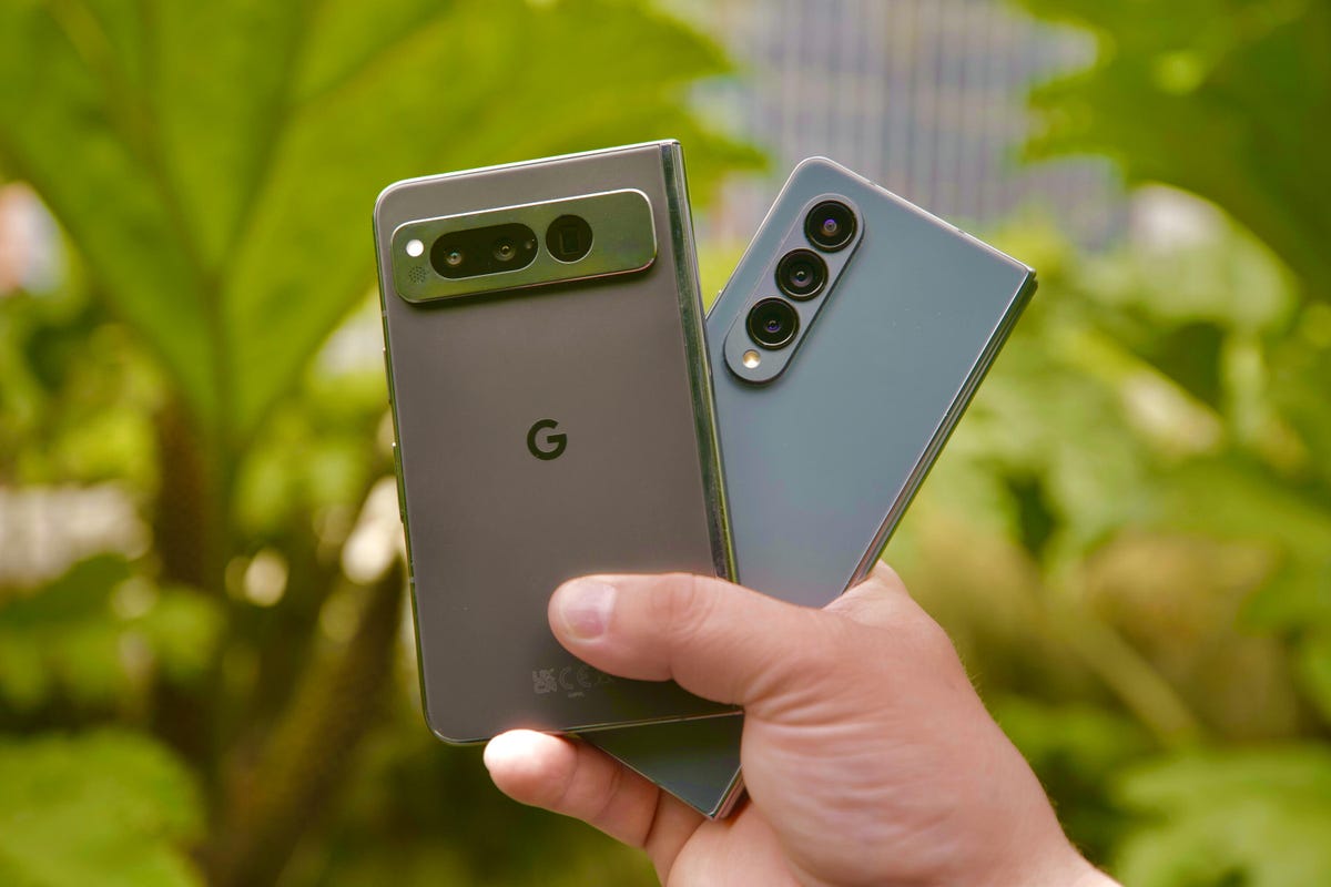 A hand holding the Google Pixel Fold and Samsung Galaxy Z Fold 4