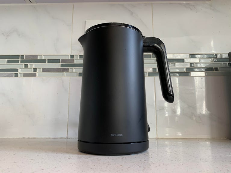 A Zwilling Enfinigy electric kettle sits in front of a tile backsplash.