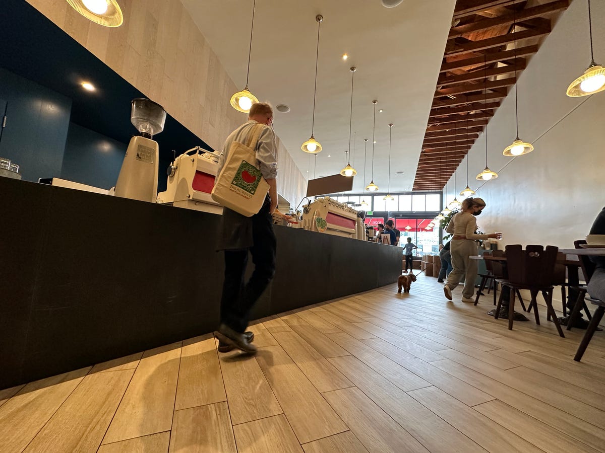 A man walking to the counter in a coffeeshop