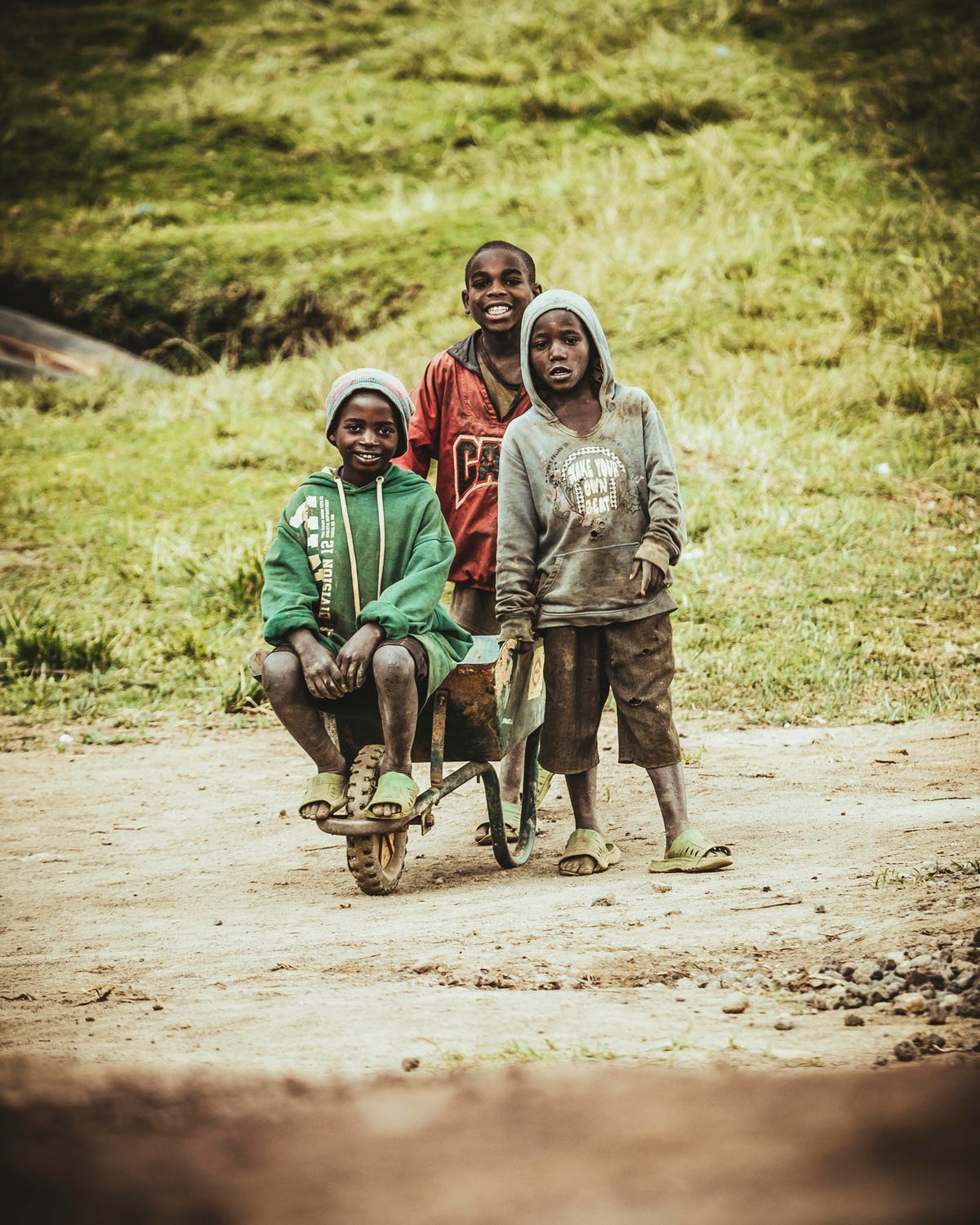 Three boys Rwanda wheelbarrow