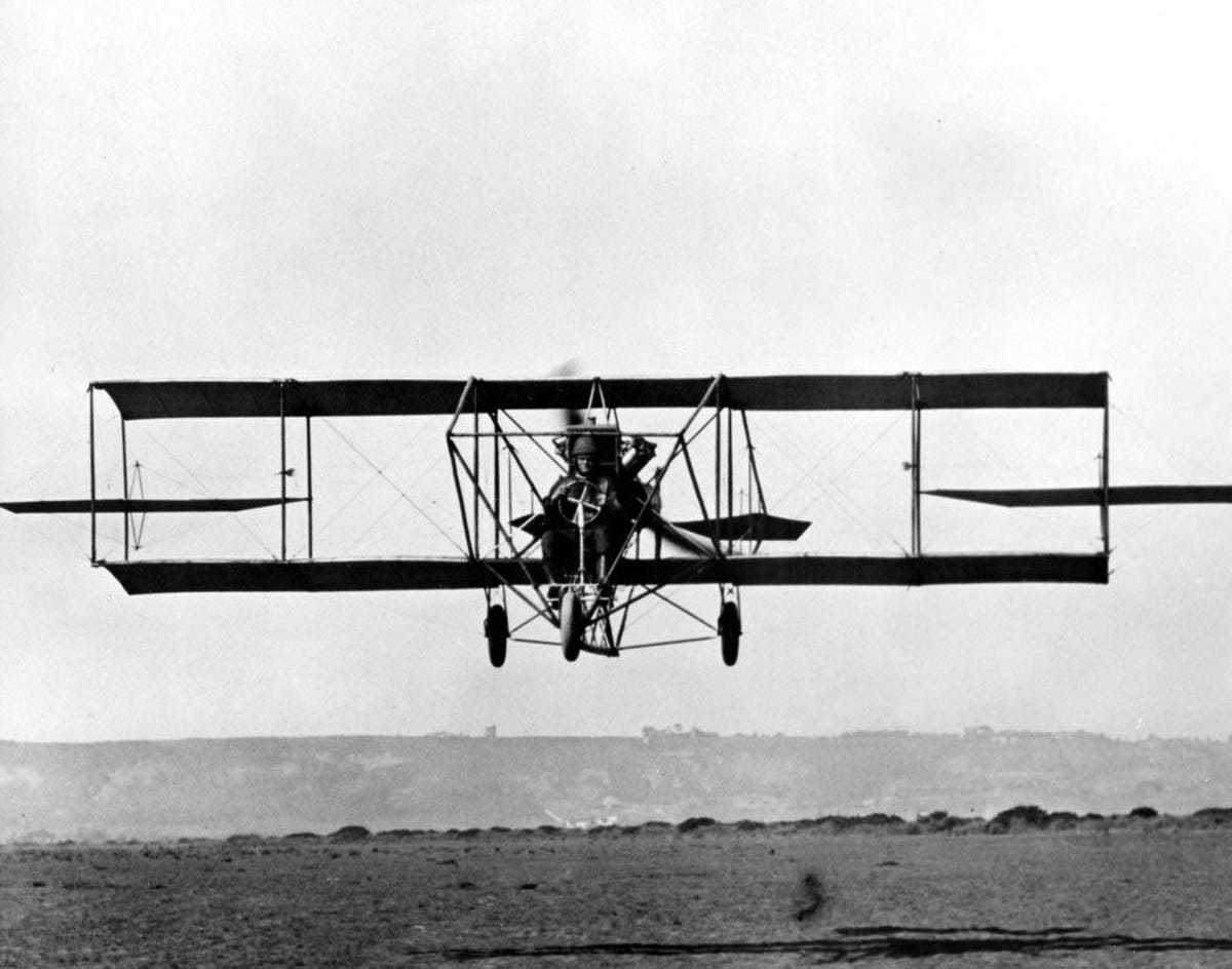 A Curtiss Model D biplane comes in for a landing
