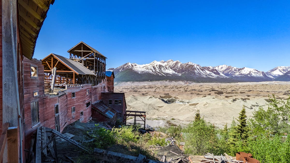 The dilapidated Kennecott Concentration Mill and the gray moraine-covered Kennicott glacier.