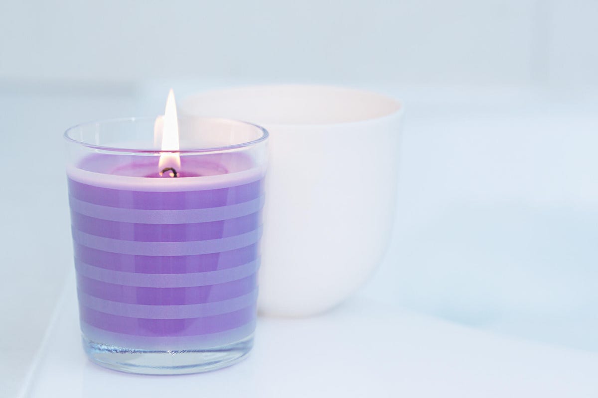 a purple candle burning on a silver background