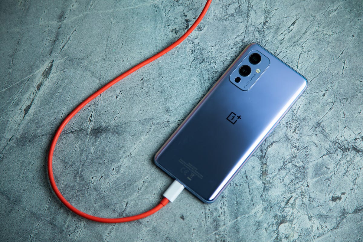 Oneplus 9 phone plugged into a charging cable