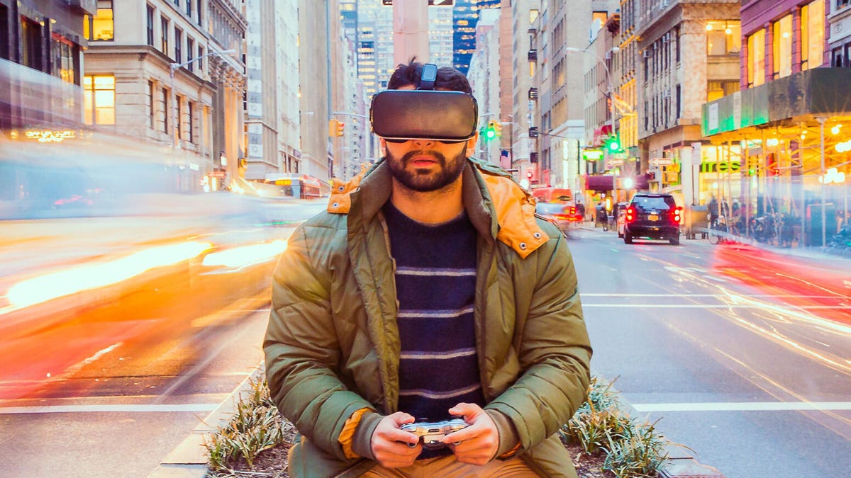Man in VR headset as traffic streams by.