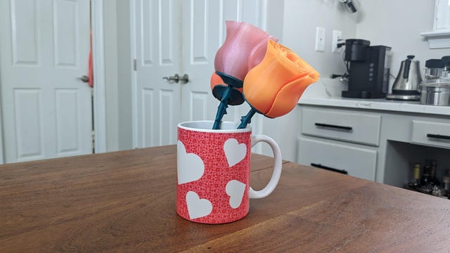 Una taza de café cubierta de corazones con rosas impresas en 3D