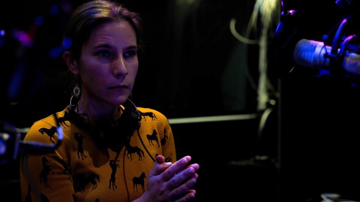 Tara Smith in a studio in front of a mic