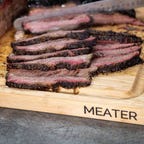 cutting board with meat sliced on top