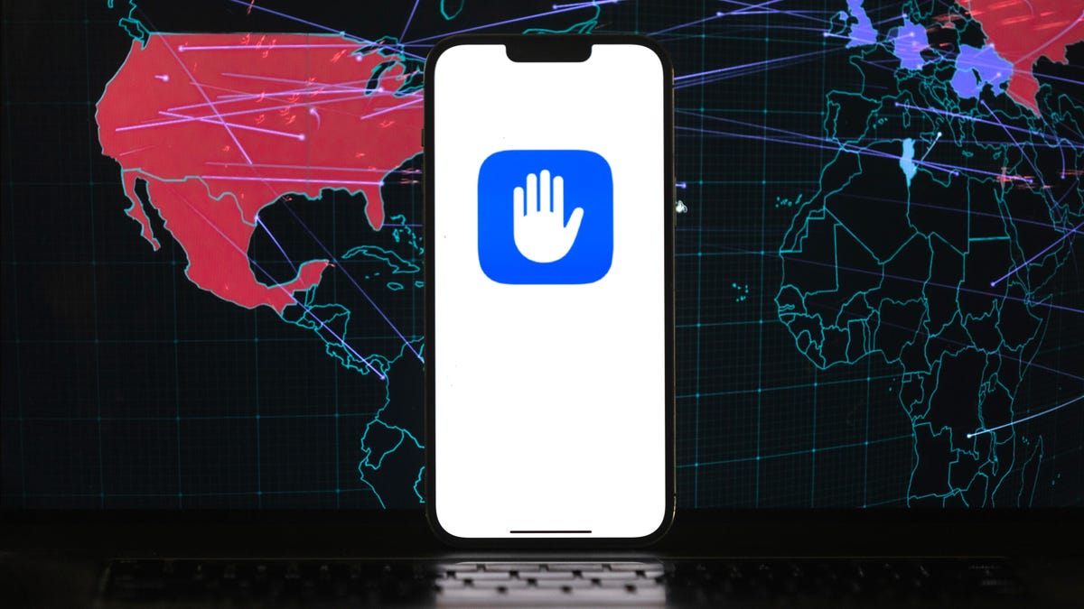An iPhone shows a hand icon indicating "halt." Behind it is a world map with lines indicating communications links.