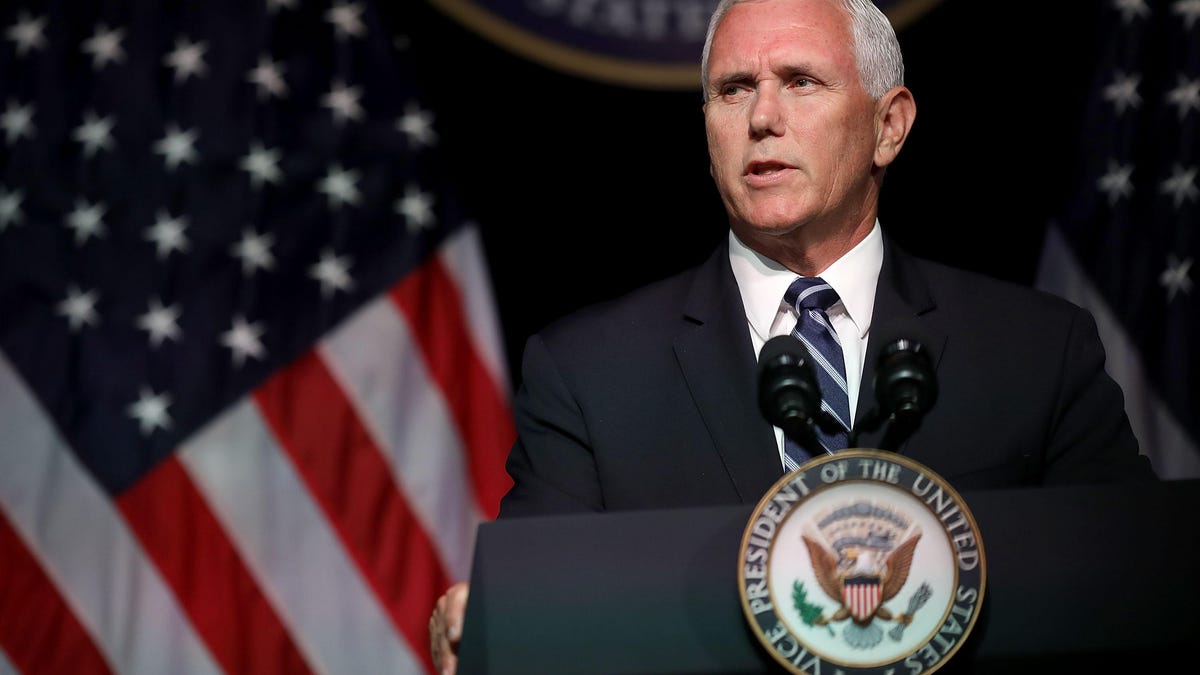 US Vice President Mike Pence giving a speech from a lectern that features the seal of the president. An American flag is visible in the background.
