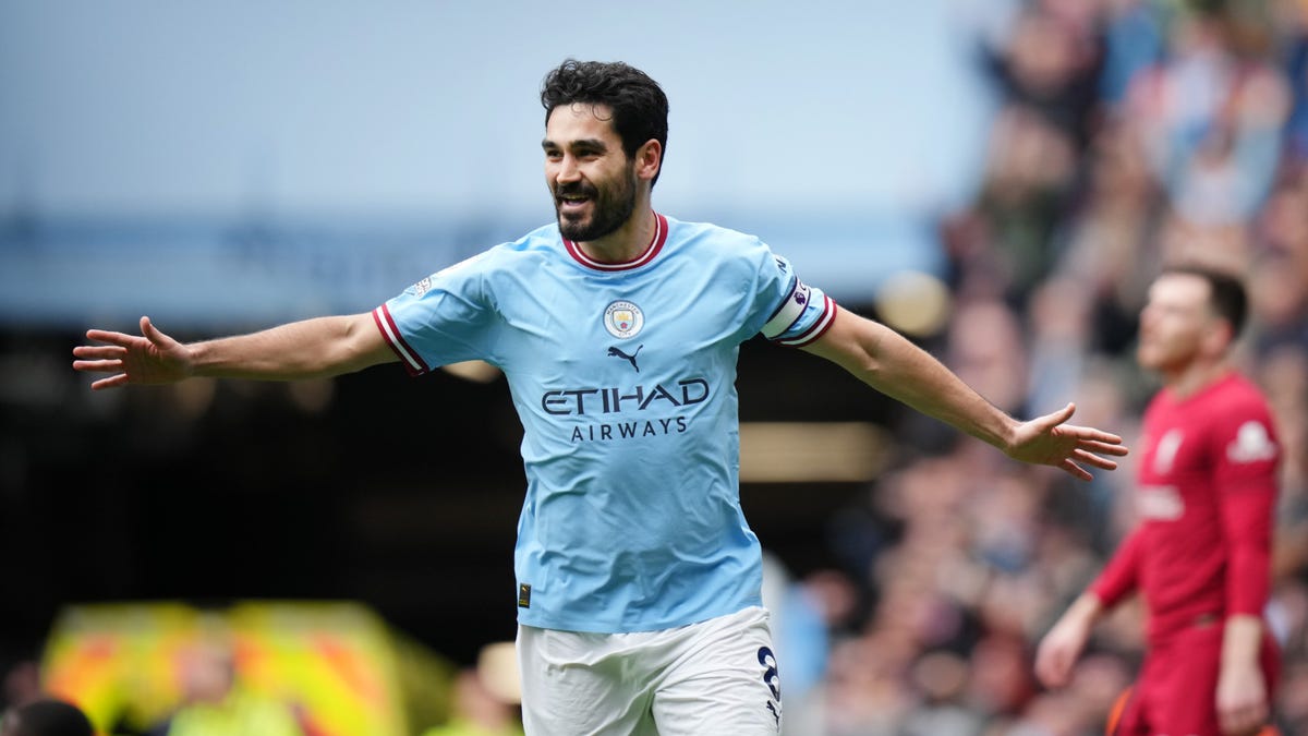 Manchester City midfielder Ilkay Guendogan celebrating with arms outstretched.
