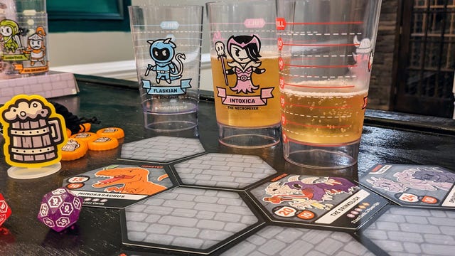 Board game tiles on a table with beer glasses in the background