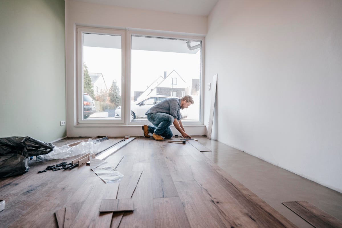 Man putting down new hardwood flooring