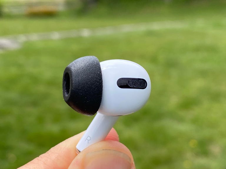 An AirPod Pro earbud with a black Comply foam tip.