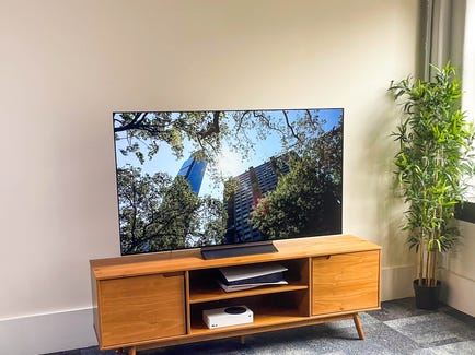 LG C OLED TV on a wood cabinet.