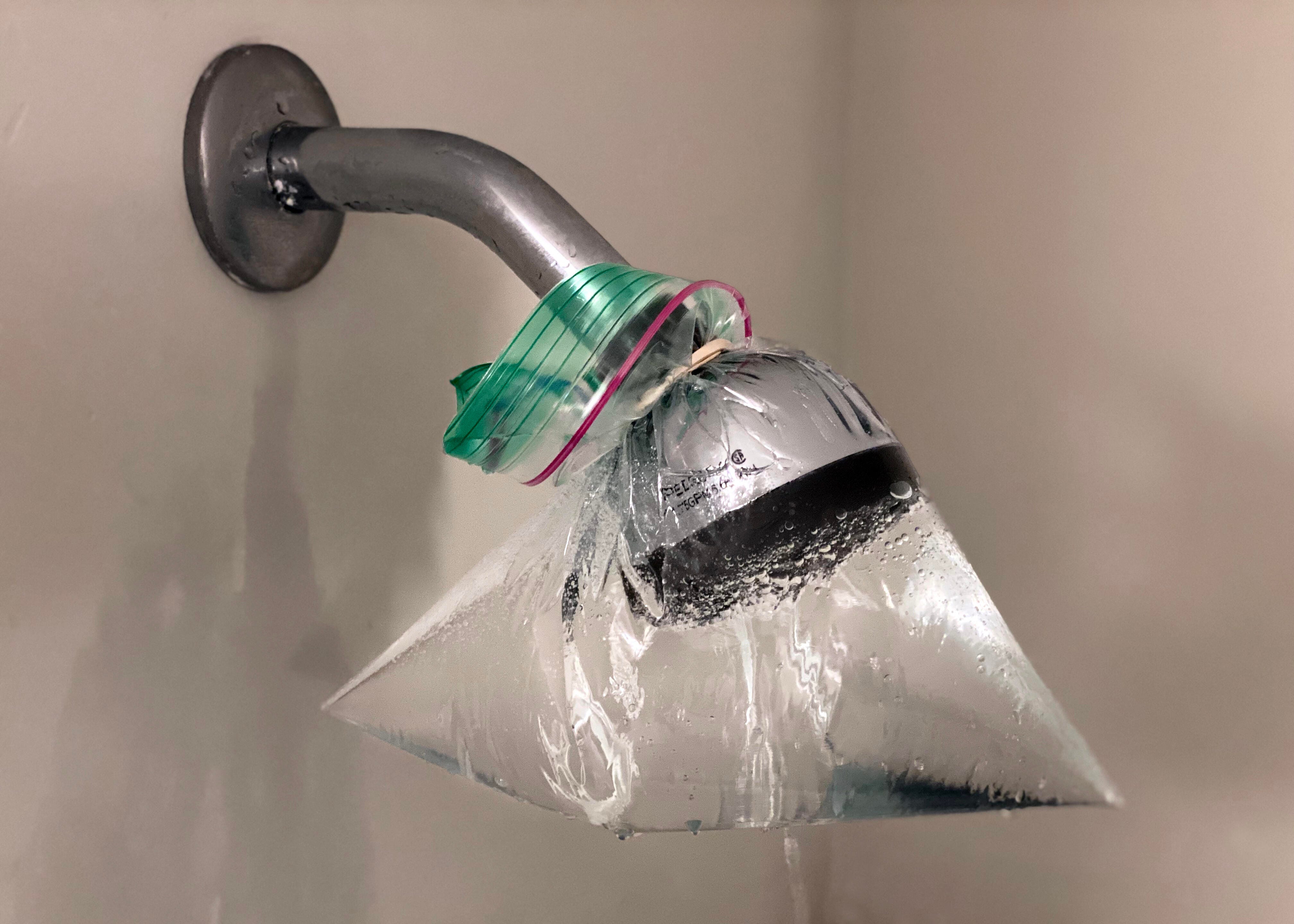 A showerhead with a bag around it.
