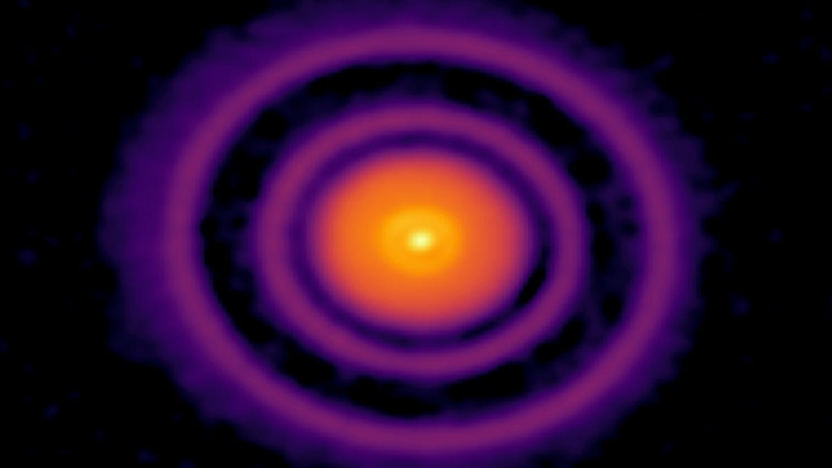 A bright orange central circle is surrounded by purple rings against a dark background.