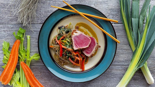 seared tuna over soba noodles on plate