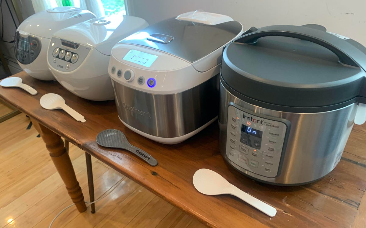 Four rice cookers side by side on a table