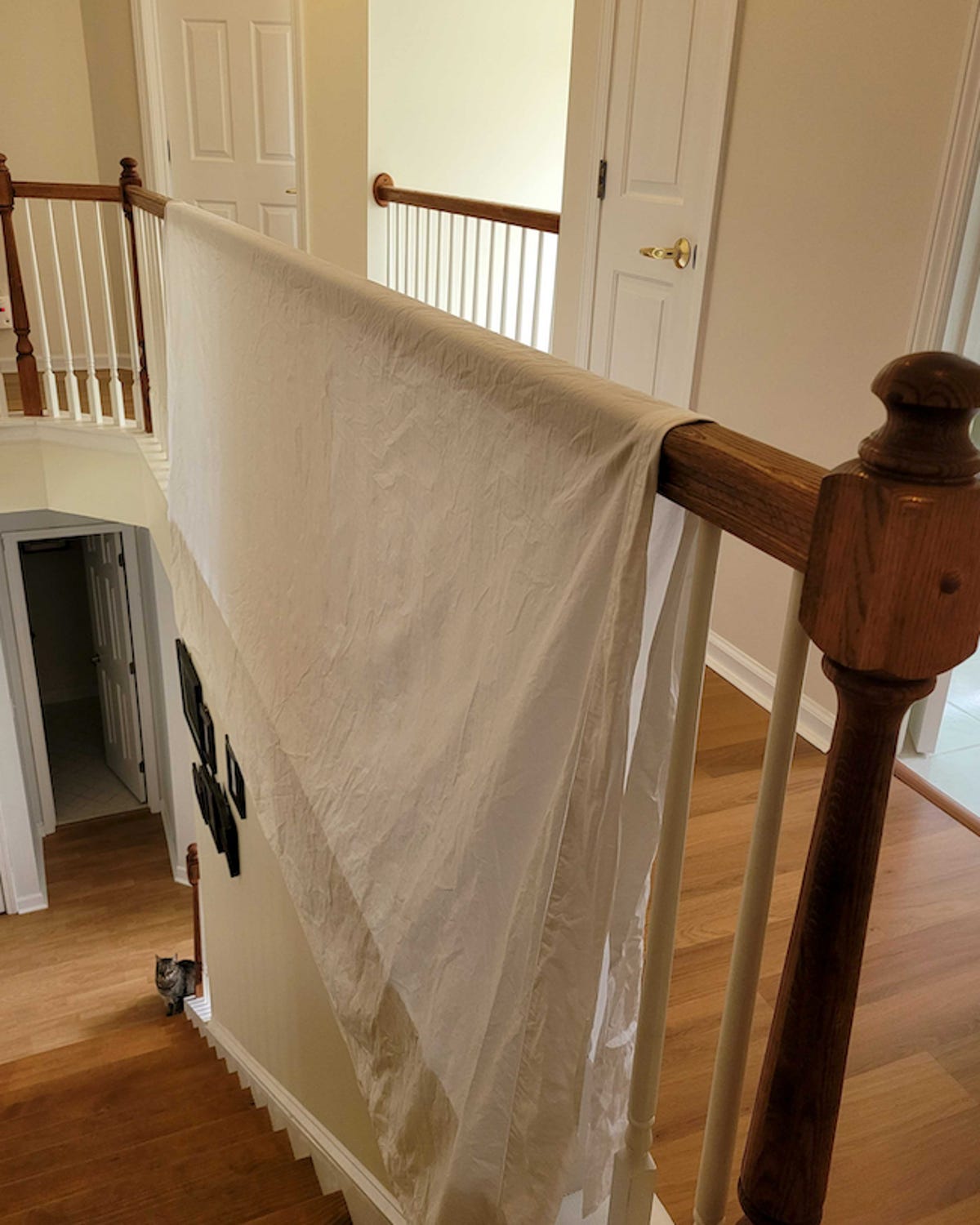 Hanging the Sferra flat sheet to dry over my stair railing.