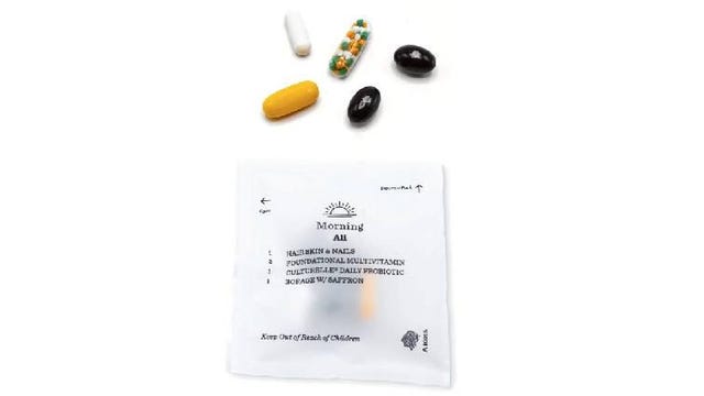 Supplements spilling out of a packet of Persona Nutrition hair, skin and nail vitamins
