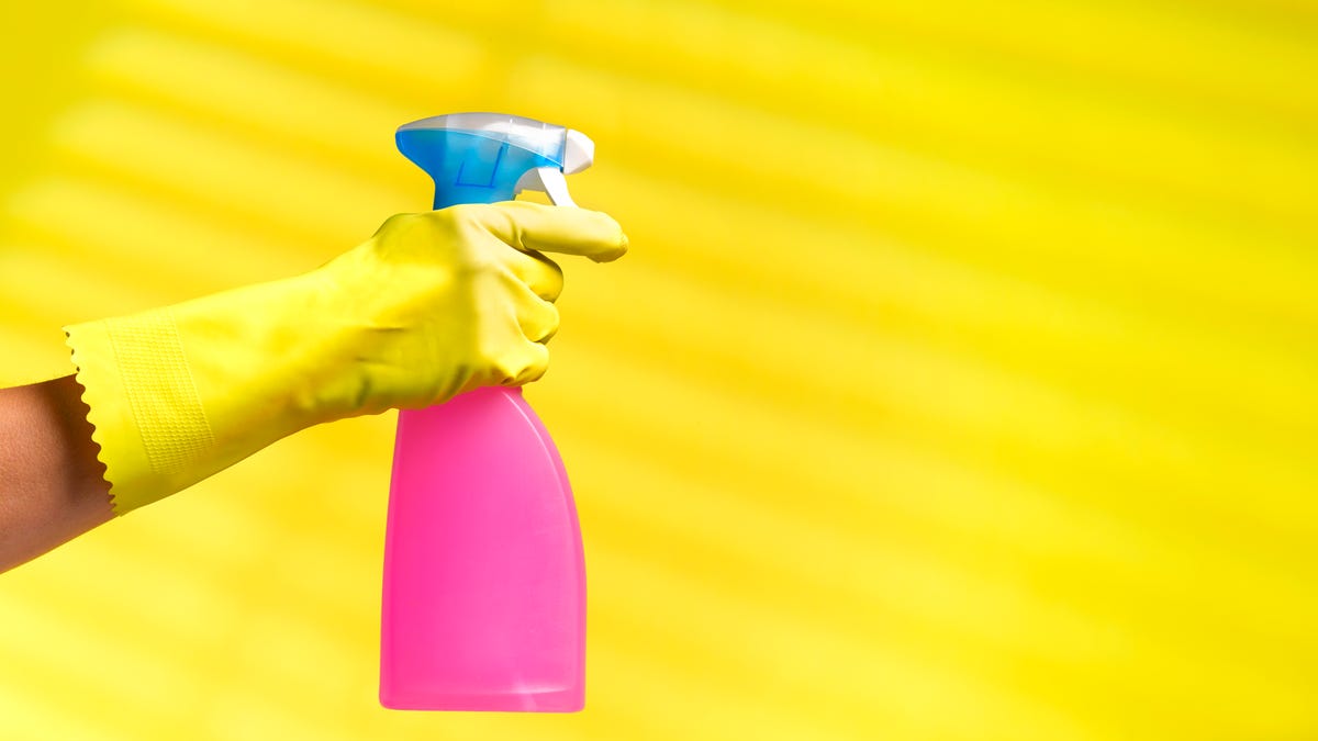 person spraying a bottle of cleaner