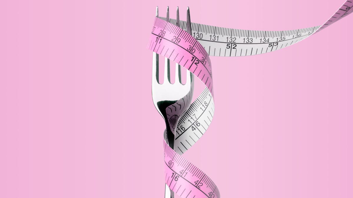 a pink measuring tape wrapped around a dinner fork